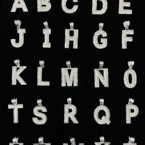 以下が含まれることがあります： 黒い持ち手と「But First, Coffee」のテキストが黒い太字で書かれた白いセラミックマグ。マグカップはぼやけた背景に置かれており、居心地の良い環境を示唆しています。