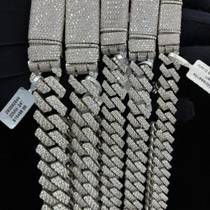 May include: A white ceramic mug with a black handle and the text "But First, Coffee" in a black, bold font. The mug is on a white surface.