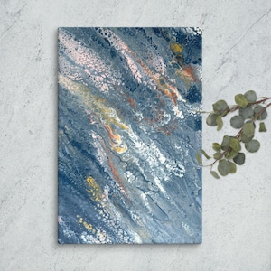 Op de afbeelding: Abstract canvas kunst met een vloeiend ontwerp. Het kunstwerk toont een mix van blauwe, witte, roze, gele en oranje tinten, waardoor een dynamische en textuurrijke uitstraling ontstaat. Het stuk is op canvas gemonteerd en klaar om te worden tentoongesteld.