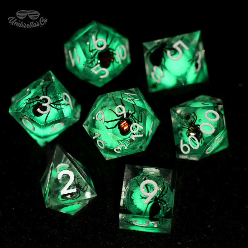 K&ouml;nnte beinhalten: Ein Set aus sieben leuchtend gr&uuml;nen W&uuml;rfeln mit wei&szlig;en Zahlen und einem schwarzen Spinnendesign im Inneren. Die W&uuml;rfel haben verschiedene geometrische Formen, darunter ein W&uuml;rfel, eine Pyramide und ein 20-seitiger W&uuml;rfel. Die W&uuml;rfel sind vor einem schwarzen Hintergrund angeordnet.