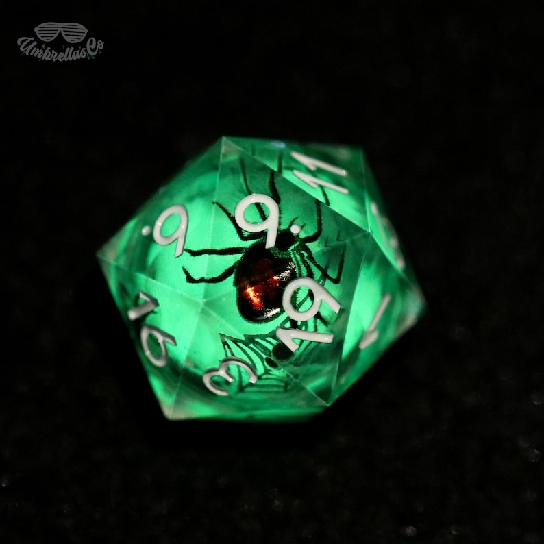 K&ouml;nnte beinhalten: Ein leuchtend gr&uuml;ner zwanzigseitiger W&uuml;rfel mit einer schwarzen Spinne und wei&szlig;en Zahlen. Die Spinne hat einen rotbraunen K&ouml;rper. Ein einzigartiger Artikel f&uuml;r Tabletop-Spiele.