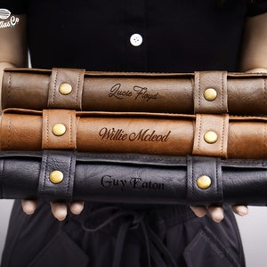 May include: Three brown leather cases with gold buckles and engraved names: Lucie Floyd, Willie McLeod, and Guy Eaton.