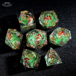 May include: A collection of seven clear resin dice with a green glitter core, showcasing red and white mushroom designs and gold numbering. The dice are in various geometric shapes, including a cube, a d20, and a d4.