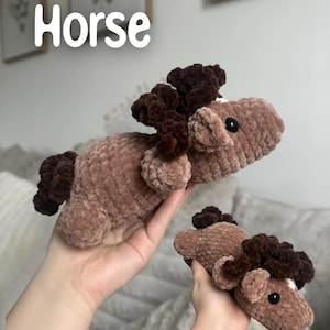May include: Two plush, crocheted horse toys in shades of brown. The horses have dark brown manes and tails, with black eyes and white markings. The word "Horse" is written in white script at the top of the image. The toys are soft and cuddly.