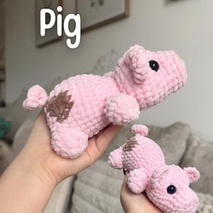 May include: Two pink crochet pig toys with brown spots. The larger pig is held in the background, while a smaller pig is held in the foreground. The word "Pig" is written in white block letters at the top of the image.