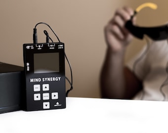 May include: A black Mind Synergy device with a small screen and buttons. The device is connected to a pair of black headphones.