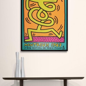 Puede incluir: Un p&oacute;ster vintage para el 17&ordm; Festival de Jazz de Montreux en 1983. El p&oacute;ster presenta una figura de palo amarilla brillante bailando sobre un fondo naranja con un suelo estampado en rosa y negro. El texto "MONTREUX 1983" est&aacute; en negro y el texto "17&egrave;me FESTIVAL DE JAZZ - JUILLET 24" est&aacute; en blanco.