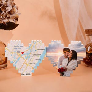 Op de afbeelding: Een hartvormige display met een kaart en een foto. De kaart toont een gedetailleerd straatbeeld met een rode hartmarker. De foto toont een stel dat elkaar omhelst. De display is gemaakt van in elkaar grijpende blokken, met de namen "Ellery & Mily".