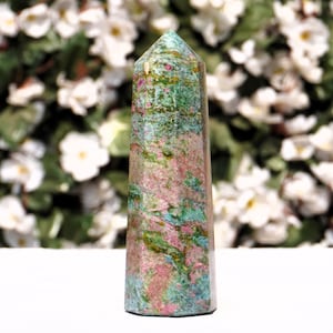 May include: A green, pink and gold crystal point with a pointed top and a flat base. The crystal is polished and has a smooth surface.