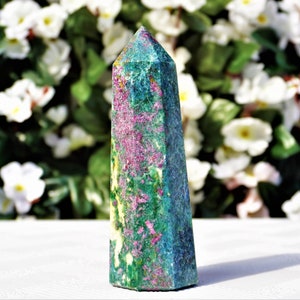 Può includere: Una punta di cristallo verde, blu e rosa con una cima appuntita e una base piatta. Il cristallo presenta un motivo a spirale di colori.