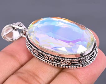 Könnte beinhalten: Ovaler Anhänger mit einem großen, schillernden Edelstein. Der Edelstein zeigt eine Reihe von Farben, darunter Blau, Grün und Gelb. Der Anhänger ist in einem silberfarbenen Metall mit einem verzierten, detaillierten Design um den Edelstein und einer dekorativen Öse gefasst.