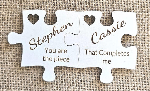 A tiny laser-cut wooden jigsaw puzzle that doubles as a fridge magnet — the 'puzzle piece' metaphor for couples is clever and the tactile keepsake format is genuinely uncommon.