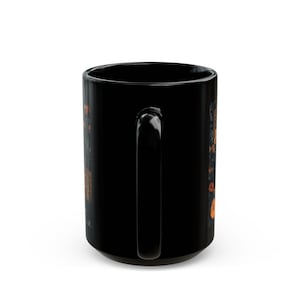 A black ceramic mug with a handle and a floral design on the side.