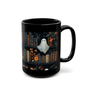 A black mug with a Halloween-themed design featuring a ghost, books, and flowers.
