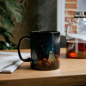 left 11 oz right night full of stars, ghosts, pumpkins, and shadow figures in the night mug for Halloween.