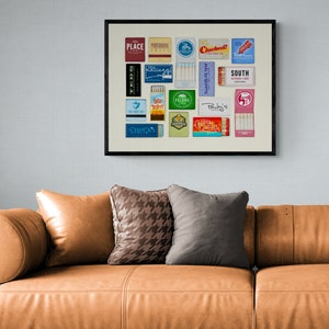 May include: A framed collage of vintage matchbox labels. The labels feature various designs and text, including "Place", "South", "Palma", "Chuck's", and "Clochehat!"