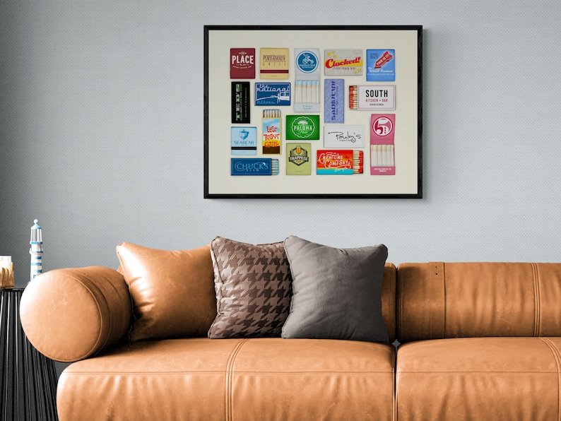 May include: A framed collage of vintage matchbox labels. The labels feature various designs and text, including "Place", "South", "Palma", "Chuck's", and "Clochehat!"