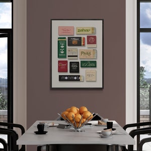 K&ouml;nnte beinhalten: Ein gerahmter Druck einer Sammlung von Streichholzschachteln mit verschiedenen Designs und Texten, darunter "morimoto", "zahal", "park" und "logista". Die Streichholzschachteln sind in einem Rastermuster auf wei&szlig;em Hintergrund angeordnet.