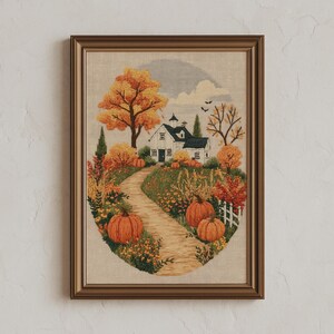 May include: A framed embroidery art piece featuring a white house with a dark roof, surrounded by orange and yellow autumn trees, a winding dirt path, and several large orange pumpkins in a garden setting, all enclosed in a brown frame.