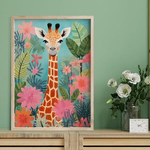 Op de afbeelding: Een ingelijste illustratie van een giraffe met een lichtbruine en oranje gepatenteerde vacht die in een jungle-omgeving staat met roze, rode en groene bloemen en bladeren.