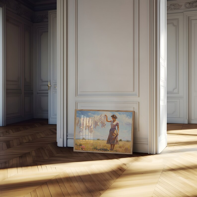 May include: A framed painting depicting a woman in a field, holding a piece of white fabric. The woman is wearing a light purple dress and a straw hat. The painting is set against a white wall with ornate moulding.