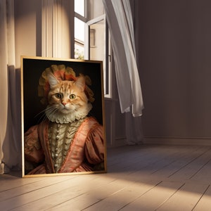 K&ouml;nnte beinhalten: Ein gerahmtes Portr&auml;t einer Katze, die ein rosa-wei&szlig;es R&uuml;schenkleid mit goldenem Rahmen tr&auml;gt.