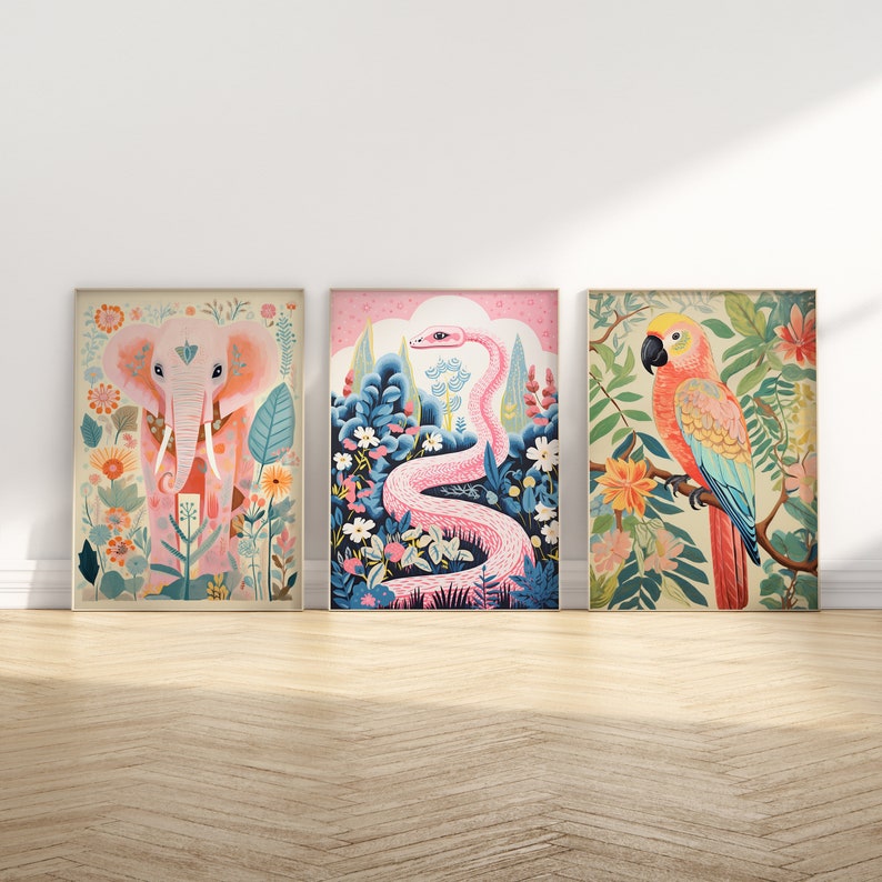 Op de afbeelding: Drie ingelijste illustraties met een roze olifant, een roze slang en een rood-blauwe papegaai. Elke illustratie is geplaatst tegen een achtergrond van kleurrijke bloemen en bladeren.