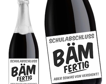 May include: Two bottles of sparkling wine with black labels that say "SCHULABSCHLUSS BÄM FERTIG ABER SOWAS VON VERDIENT!"  The labels are white with black text.
