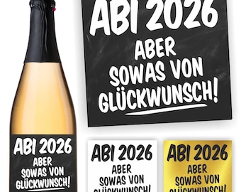 May include: A champagne bottle with a black label displaying the text "ABI 2026 ABER SOWAS VON GLÜCKWUNSCH!". The image also shows three square stickers with the same text, one on a black background, one on white, and one on gold.