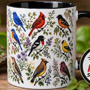 May include: A white ceramic mug with a black handle and interior, featuring a detailed pattern of various colorful songbirds perched on flowering branches. The birds include a bluebird, cardinal, oriole, and others amidst floral elements.