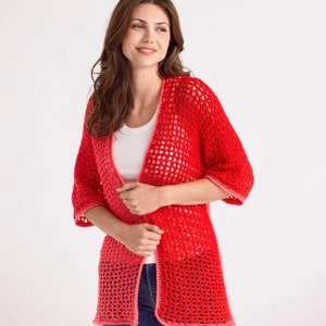 May include: A red, open-weave crochet cardigan with three-quarter sleeves. The cardigan is a vibrant red color, with a slightly lighter shade at the bottom hem and sleeve cuffs. The garment is worn over a white top.
