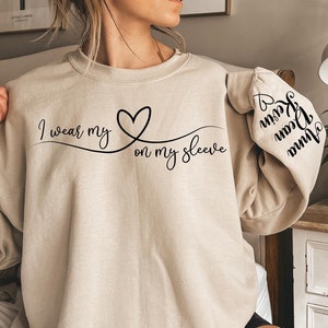 I Wear My Heart On My Sleeve Sweatshirt, Mothers Day Hoodie, Mom Sweater with Kids Name on Sleeve, Custom Mother Day Gift, Mom Birthday Gift
