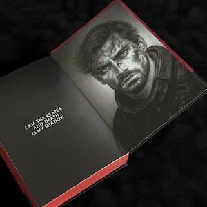 May include: An open hardcover book with red-edged pages. The left page features the black text: I AM THE REAPER AND DEATH IS MY SHADOW. The right page displays a detailed black and white illustration of a man with a serious expression and messy hair.