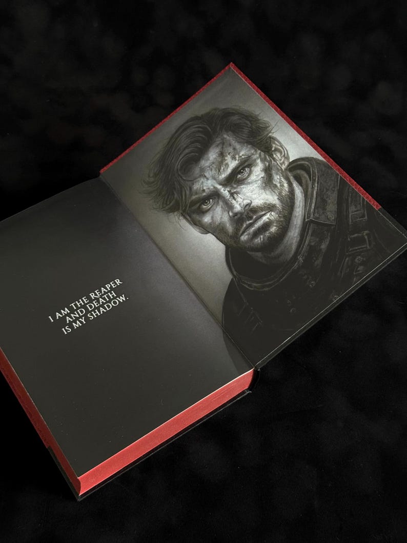May include: An open hardcover book with red-edged pages. The left page features the black text: I AM THE REAPER AND DEATH IS MY SHADOW. The right page displays a detailed black and white illustration of a man with a serious expression and messy hair.