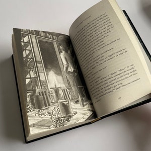 May include: A close-up of an open book with a black and white illustration of a man standing in a doorway. The man is wearing a suit and hat. The book is open to a page with text about a man who is "drunker than I'd ever seen him".