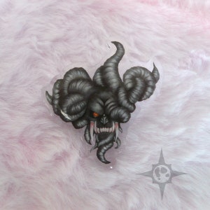 May include: A black and white illustration of a demonic creature with large horns and sharp teeth. The creature has a single red eye and a menacing expression.