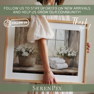May include: A framed print featuring a serene interior scene with white flowers in wicker baskets, rolled white towels, and a window. The print is held by a person. Text on the frame says "FOLLOW US" and "Thank you!" and "SERENPIX".