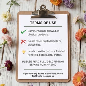 May include: A clipboard with a white paper that has the text "TERMS OF USE". The text includes information about commercial use, reselling, and label usage. The clipboard is on a wooden surface with flowers.