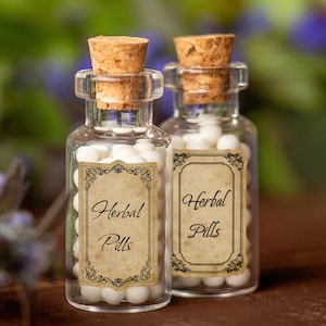 Puede incluir: Dos peque&ntilde;as botellas de vidrio con tapones de corcho llenas de p&iacute;ldoras blancas. Ambas botellas tienen etiquetas de estilo vintage que dicen "Herbal Pills".