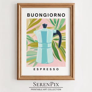 Könnte beinhalten: Ein gerahmter Druck mit einer blauen und weißen Espressomaschine auf rosa Hintergrund mit grünen Blättern. Der Text "BUONGIORNO ESPRESSO" ist unter dem Bild gedruckt.
