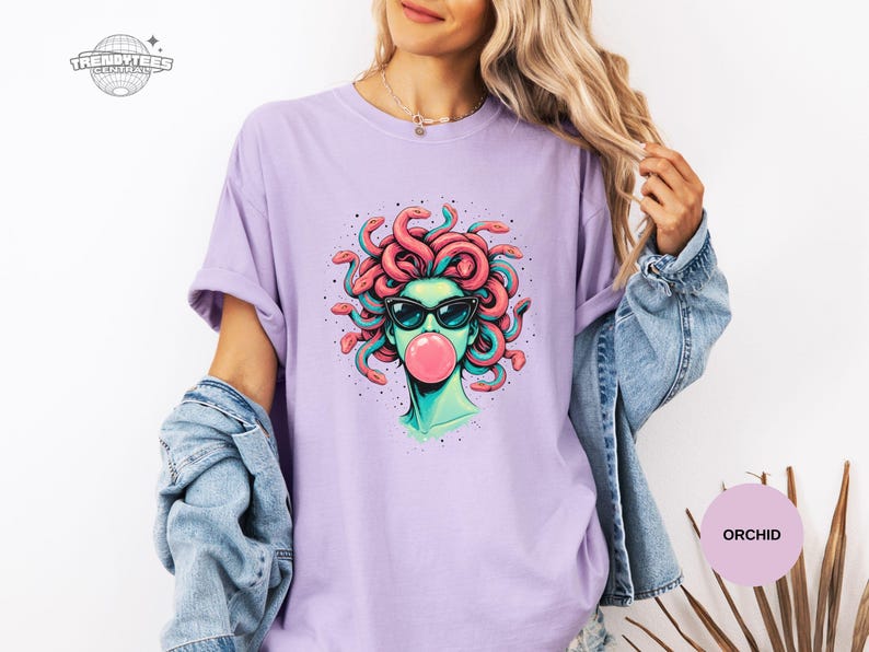 Orchid lavender Comfort Colors tee with the Medusa bubblegum portrait centered. The pastel purple gives the design a softer, feminine edge while keeping the art bold. Great for buyers who like witchy aesthetics in lighter tones.