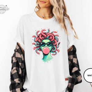 White Comfort Colors t-shirt with the Medusa portrait and pink bubblegum bubble printed in the center. The white base makes every color in the design look brighter and more detailed. Clean option for shoppers who like crisp, high-contrast graphics.
