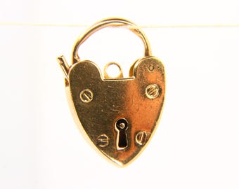 May include: A gold-colored heart-shaped padlock with a curved handle. The padlock has a keyhole and is secured with small screws. The design is simple and elegant, suitable for jewelry or decorative purposes.