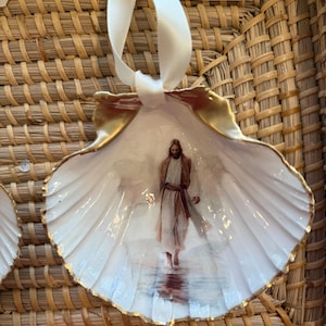 May include: A white ceramic mug with a black handle and the text "But First, Coffee" in a black, bold font. The mug is on a white surface.