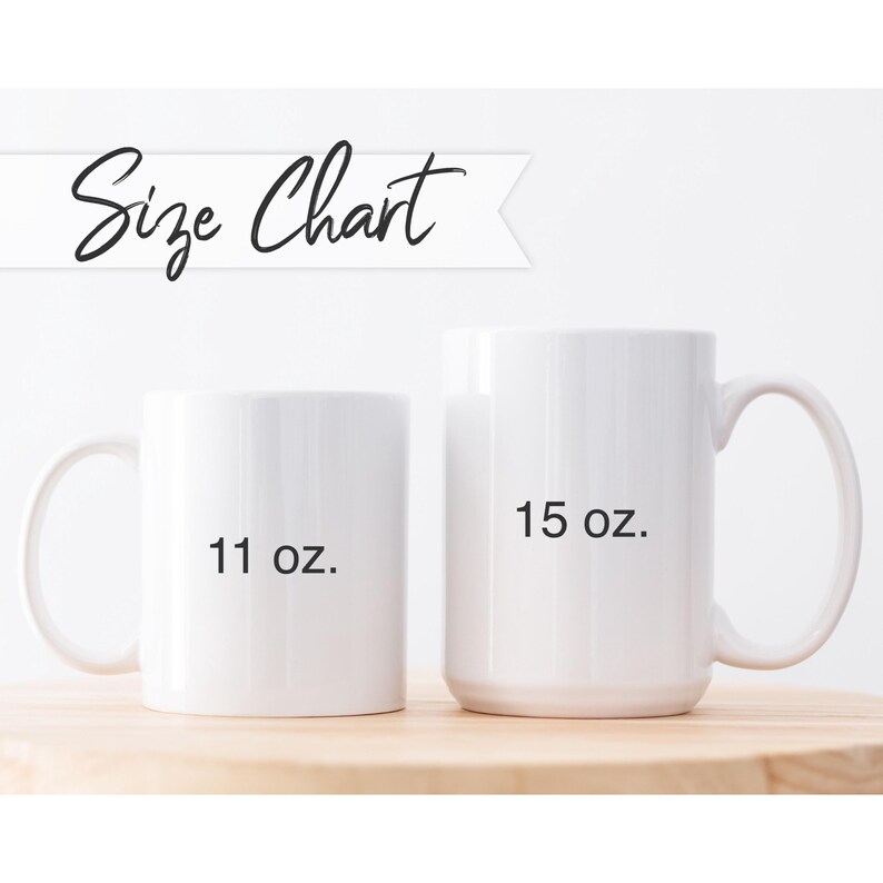 May include: Two white ceramic mugs of different sizes are displayed on a wooden surface. The smaller mug is labeled "11 oz." and the larger mug is labeled "15 oz." Above the mugs is the text "Size Chart" in a script font.