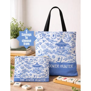 May include: A tote bag and a zippered pouch with a blue and white toile pattern featuring a pagoda, dice, and Mahjong tiles. The tote bag has black handles and the text "JOKER HUNTER". The pouch has the text "THE JOKER HUNTER".