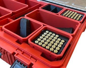 Könnte beinhalten: Rote Kunststoff-Aufbewahrungsbox mit mehreren Fächern, gefüllt mit Munition und einem schwarzen Magazin. Die Box hat einen schwarzen Verschluss mit dem aufgedruckten Wort "Milwaukee".