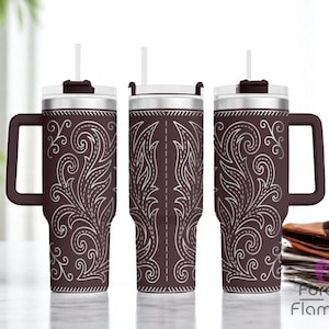 Pode incluir: Um conjunto de tr&ecirc;s canecas t&eacute;rmicas marrons com desenhos florais brancos. Cada caneca tem uma al&ccedil;a, um canudo branco e uma tampa. As canecas est&atilde;o em uma superf&iacute;cie clara. Altura aproximada de 20 cm.