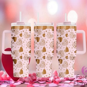 May include: Three pink stainless steel tumblers with a gold heart and leaf pattern. The tumblers have a pink lid and a pink handle.