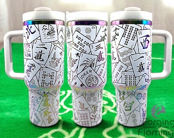 May include: Three white stainless steel travel mugs with a black and white mahjong tile pattern. The mugs have a rainbow iridescent finish and a black lid with a white handle.